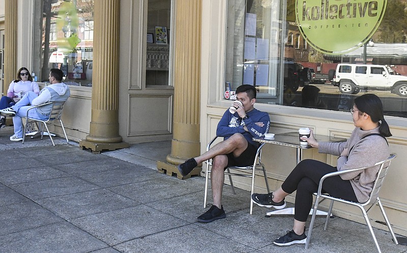 Julius, left, and Renlie Catapusan enjoy coffee outside of Kollective Coffee + Tea in downtown Hot Springs on Wednesday. - Photo by Grace Brown of The Sentinel-Record