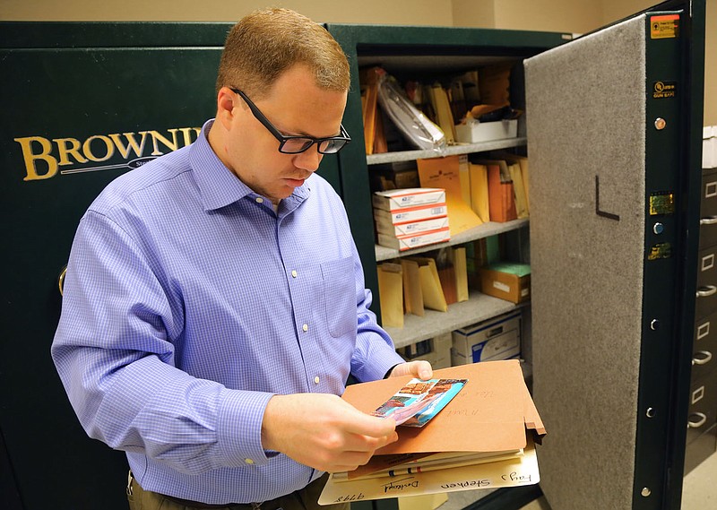 Skot Covert, then a spokesman with the Arkansas State Auditor’s office, looks through some of the unclaimed items the office was trying to reunite with their owners in this March 2016 file photo.