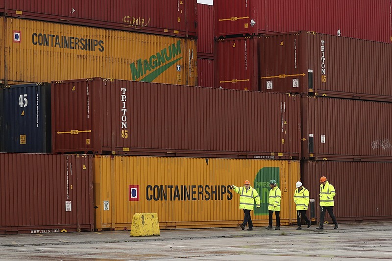 Britain's Prime Minister Boris Johnson, left, and Chancellor of the Exchequer Rishi Sunak, second right, walk past shipping containers during a visit to Teesport in Middlesbrough, England, Thursday, March 4, 2021. Britain's Chancellor Rishi Sunak and Prime Minister Boris Johnson visited the north east following the Budget announcement that the Treasury and other government departments will be sited on an economic campus in Darlington and that Teeside and The Humber would be among eight new freeports in England. (AP Photo/Scott Heppell, pool)