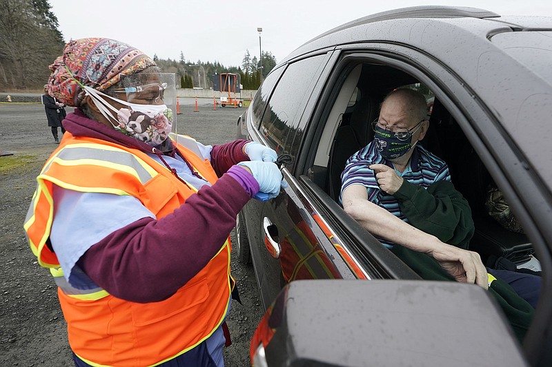 Douglas Burden, right, a U.S. Marine Corps. veteran, receives the first dose of the Pfizer COVID-19 vaccine, Thursday, March 4, 2021, at a mobile vaccination clinic run by the VA Puget Sound Health Care System in Shelton, Wash., from nurse Jennifer Terry, left. The VA announced this week that they are now scheduling vaccine appointments for veterans of any age who are already receiving care from the VA, and said they have been bringing mobile clinics to rural communities such as Shelton as a way to reach patients who would otherwise have to drive to Seattle or Tacoma, Wash., to be vaccinated. (AP Photo/Ted S. Warren)