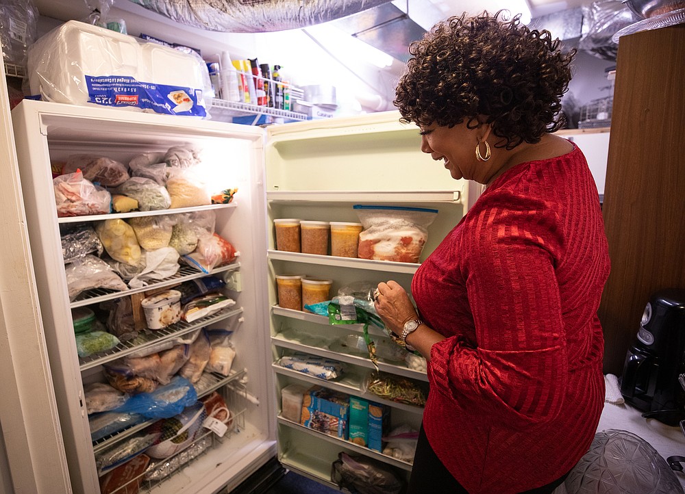 Doris Vincent with her freezer, which stands in addition to her three refrigerators. (The New York Times/Swikar Patel)