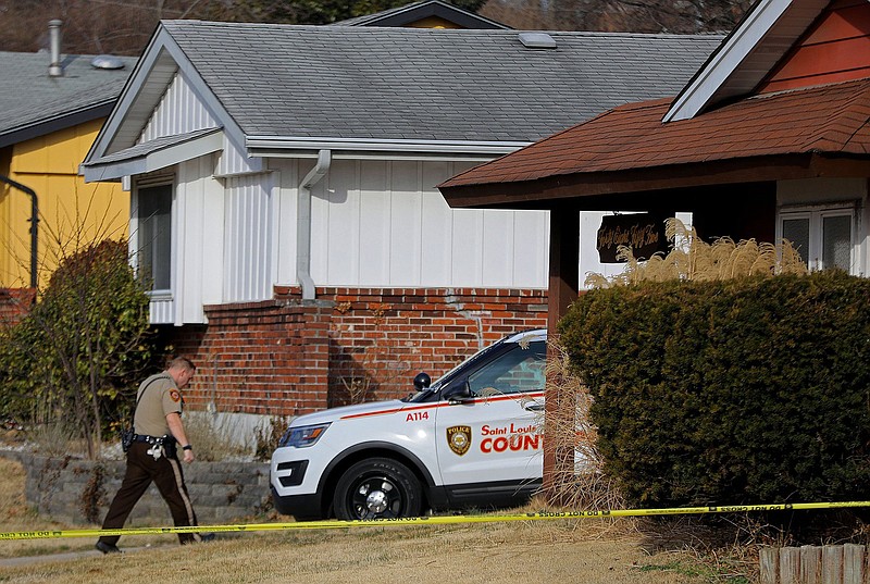 A St. Louis County police officer keeps watch over a home in the 4800 block of Lockwig Trail in north St. Louis County on Friday, March 5, 2021, where Bobby McCulley III allegedly shot and killed a woman and her two children. (Christian Gooden/St. Louis Post-Dispatch via AP)