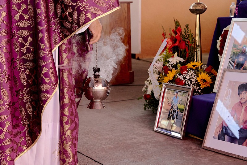 Photographs of Herminio Paz, who died from the coronavirus, are displayed at his funeral Mass at Our Lady of Lourdes Catholic Church in East Los Angeles on Feb. 27. The Rev. Jesus Zamarripa now leads services in the church’s parking lot, which has been converted into an airy and shaded outdoor chapel.
(The New York Times/Philip Cheung)