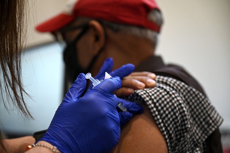 Nurse Joyce Moore gives a dose of the Pfizer vaccine to Maqbool Bhati at a UAMS vaccine clinic in University Park in Little Rock on Monday, March 8, 2021. (Arkansas Democrat-Gazette/Stephen Swofford)
