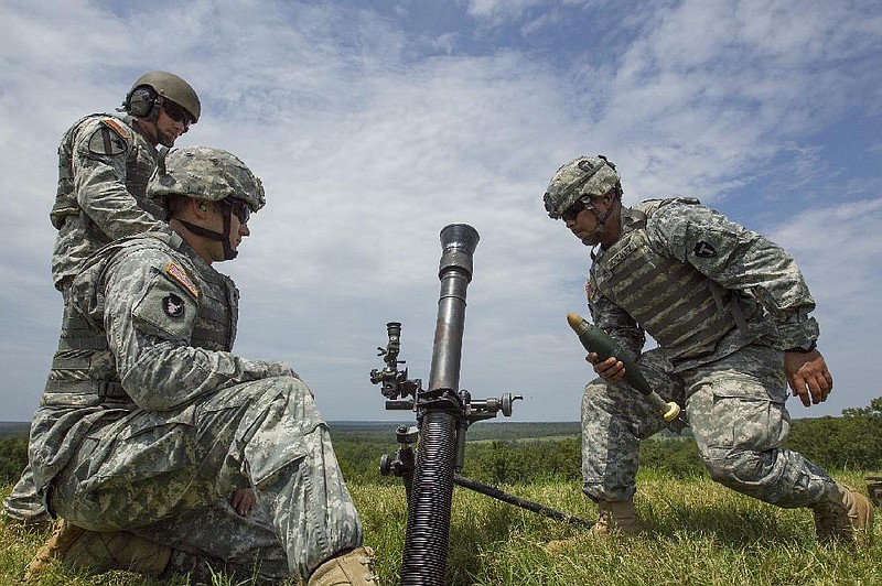 FILE — Justin Fisher, back left, from North Little Rock, Chris Zimbelman, front left, from Des Moines, IA, and Juan Gonzalez, from San Antonio, TX, fire an 81mm mortar round from a range at Camp Robinson during the only day of live fire exercises of a 4 week Mortarman training course in this Aug. 7, 2014 file photo. (Arkansas Democrat-Gazette — FILE)