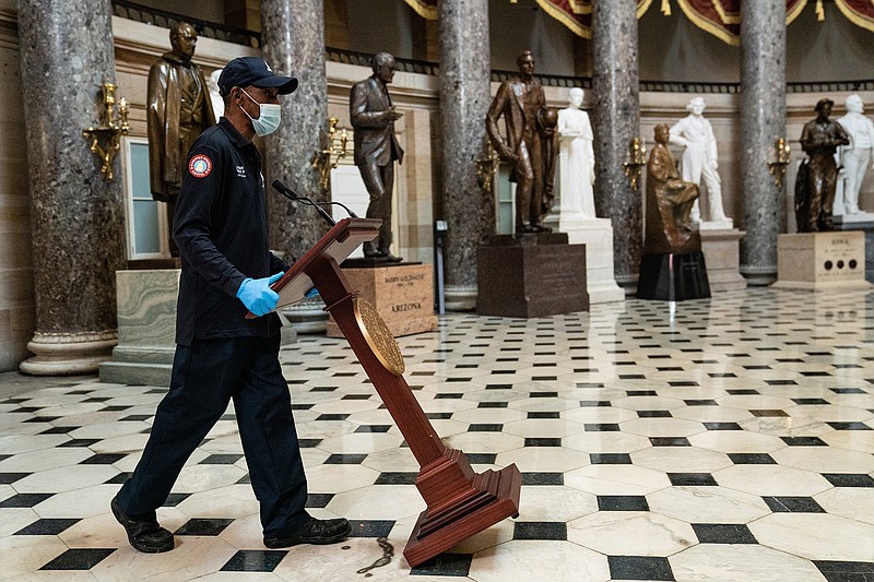 A worker pushes a lectern through Statuary Hall at the U.S. Capitol for a news conference Wednesday by House Speaker Nancy Pelosi and other Democrats after the House approved President Joe Biden’s $1.9 trillion coronavirus relief package.
(The New York Times/Anna Moneymaker)