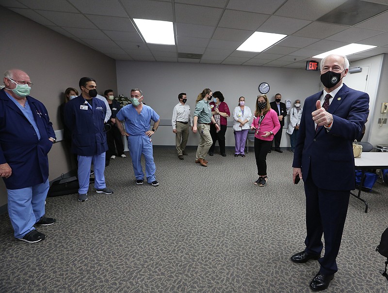 Gov. Asa Hutchinson gives thumbs up to doctors and nurses after a ceremony marking the state's first case of Covid-19 on Thursday, March 11, 2021, at Jefferson Regional Medical Center in Pine Bluff. .More photos at www.arkansasonline.com/312jrmc/.(Arkansas Democrat-Gazette/Thomas Metthe)