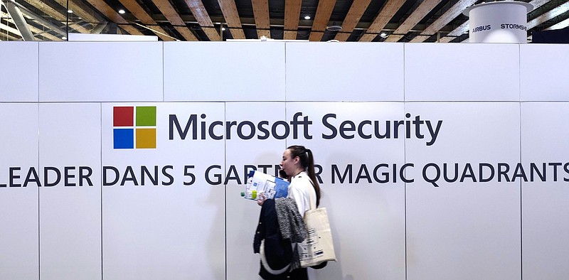 A woman passes the Microsoft stand during a cybersecurity conference last year in Lille, France. Microsoft is investigating the possibility a leak of details about a scheduled February software patch release triggered a huge cyberattack.
(AP)