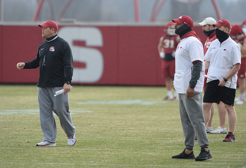 Arkansas defensive coordinator Barry Odom (left) watches from the sidelines Thursday, March 11, 2021, during practice at the university practice facility in Fayetteville. Visit nwaonline.com/210312Daily/ for today's photo gallery. .(NWA Democrat-Gazette/Andy Shupe)