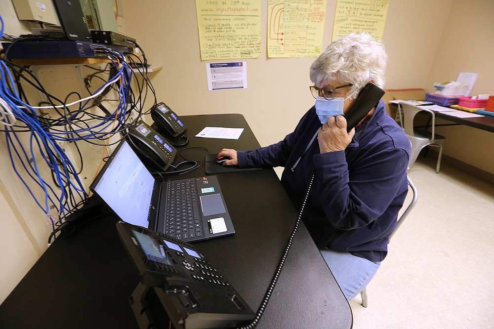 Leslie Trammell takes a phone call while setting up vaccine appointments Thursday at Doctor’s Orders Pharmacy in Pine Bluff. Pharmacy owner Lelan Stice has been busy organizing supplies and remote vaccination clinics.
(Arkansas Democrat-Gazette/Thomas Metthe)