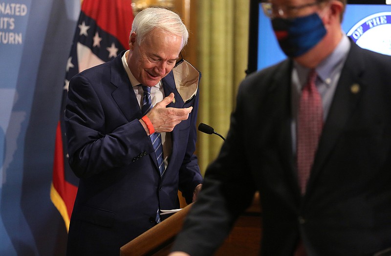 Gov. Asa Hutchinson takes off his mask before speaking during the weekly covid-19 briefing on Tuesday, March 16, 2021, at the state Capitol in Little Rock. .(Arkansas Democrat-Gazette/Thomas Metthe)