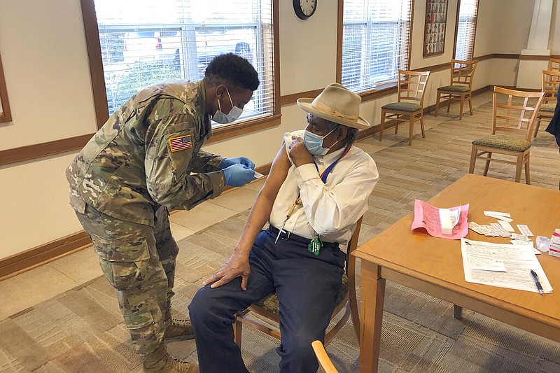 The Rev. Oliver Savage gets a covid-19 vaccine from Missouri National Guard member Richard Waithira on Thursday, March 4, 2021, during a vaccination clinic at a St. Louis senior center. (AP/Jim Salter)