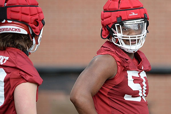 Arkansas defensive lineman Eric Gregory (right) takes part in a drill Thursday, March 11, 2021, during practice at the university practice facility in Fayetteville.