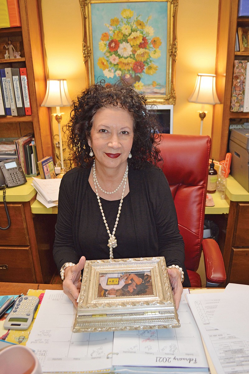 Teresa Little holds a photo-frame box filled with special notes from parents as she sits at her desk in Milestones Services Inc., formerly the Faulkner County Day School, in Conway. Little started with the early-education program almost 38 years ago, and she became executive director 4 1/2 years ago. The program is celebrating its 60th anniversary.