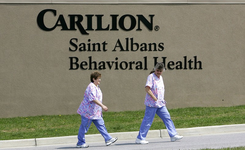People walk past a sign of the Carilion St. Albans hospital in Christiansburg, Va., a mental health facility, in this Wednesday, April 18, 2007, file photo. (AP/Charles Dharapak)