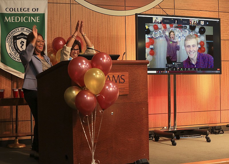 Bryce Wall announces his residency match virtually Friday as Sharanda Williams (left), assistant dean for student affairs for the College of Medicine at the University of Arkansas for Medical Sciences, and Dr. Sara Tariq, associate dean for student affairs for the UAMS College of Medicine, applaud during the annual Match Day ceremony at UAMS in Little Rock. Wall matched as an orthopedic surgery resident at UAMS. More photos at arkansasonline.com/320match/.
(Arkansas Democrat-Gazette/Staton Breidenthal)