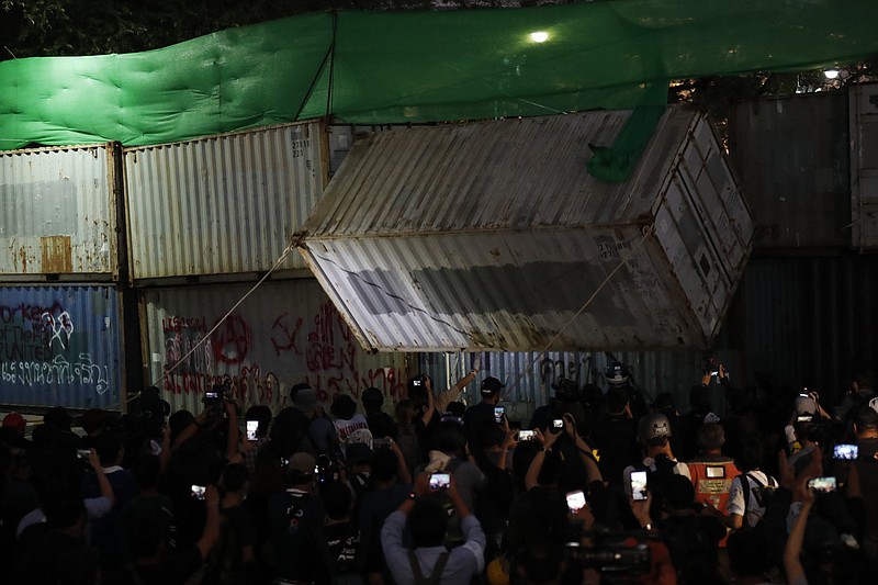 Protesters pull down a shipping container used as a barricade Saturday in front of the Grand Palace in Bangkok, as Thailand’s student-led pro-democracy movement presses for the release of its jailed leaders.
(AP/Sakchai Lalit)