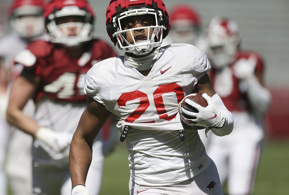 Arkansas running back Dominique Johnson (20) carries the ball Saturday during the Razorbacks’ scrimmage at Reynolds Razorback Stadium in Fayetteville. (NWA Democrat-Gazette/Charlie Kaijo)