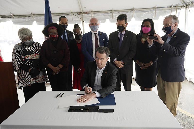 Surrounded by legislators and activists Wednesday at Greensville Correctional Center in Jarratt, Va., Gov. Ralph Northam signs a bill abolishing the death penalty in Virginia.
(AP/Steve Helber)