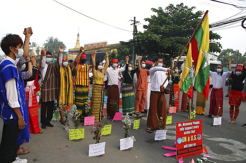 Anti-coup protesters hold hands during a rally in Rangoon, Burma, on Thursday, March 25, 2021, as a sign says the "Myanmar people" want the United States and United Nations to take action. Burma is often called Myanmar, a name that ruling military authorities adopted in 1989. (AP Photo)