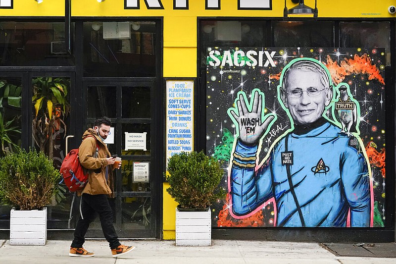 A pedestrian wears his mask below his mouth and nose as he walks past street art depicting Dr. Anthony Fauci as a six-fingered Mr. Spock from "Star Trek" on Friday, March 26, 2021, in the East Village neighborhood of New York. A year after becoming a global epicenter of the coronavirus pandemic, New York and New Jersey are back atop the list of U.S. states with the highest rates of infection. (AP/Mary Altaffer)