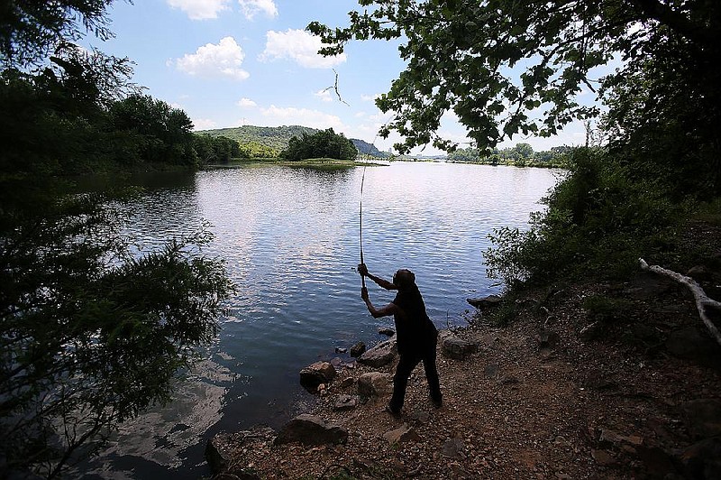 Adrian Meeks of North Little Rock casts his line in the Arkansas River while fishing in North Little Rock's Burns Park in this June 7, 2018, file photo. (Arkansas Democrat-Gazette/THOMAS METTHE)