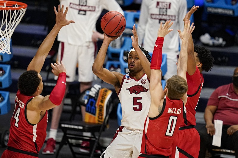 Arkansas guard Moses Moody (5) shoots over Texas Tech forward Marcus Santos-Silva (14) and guard Mac McClung (0) in the second half of a second-round game in the NCAA men's college basketball tournament at Hinkle Fieldhouse in Indianapolis, Sunday, March 21, 2021. (AP Photo/Michael Conroy)
