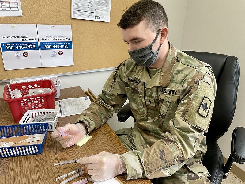 A member of the Arkansas National Guard prepares COVID-19 vaccines at the Union County Local Health Unit. (Marvin Richards/News-Times)