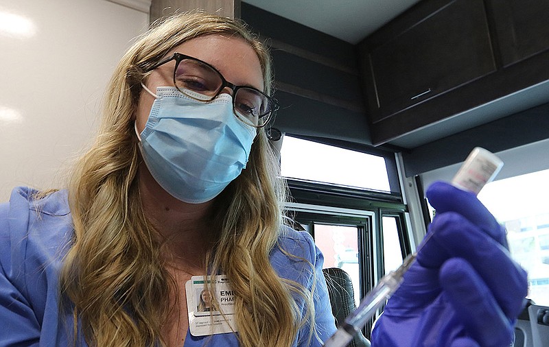 Pharmacist Emily Sprick fills syringes with the Pfizer covid-19 vaccine Wednesday during a vaccination clinic at the River Cities Travel Center in downtown Little Rock. (Arkansas Democrat-Gazette/Thomas Metthe)