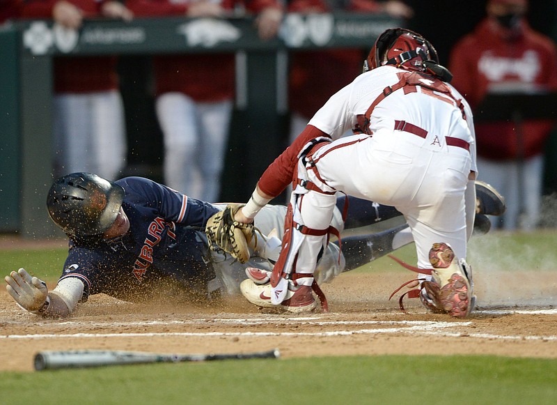 Arkansas catcher Casey Opitz (right) tags out Auburn second baseman Brody Moore at home during the fifth inning Thursday at Baum-Walker Stadium in Fayetteville. The No. 2 Razorbacks lost 2-1 to the Tigers. More photos at arkansasonline.com/42auua.
(NWA Democrat-Gazette/Andy Shupe)