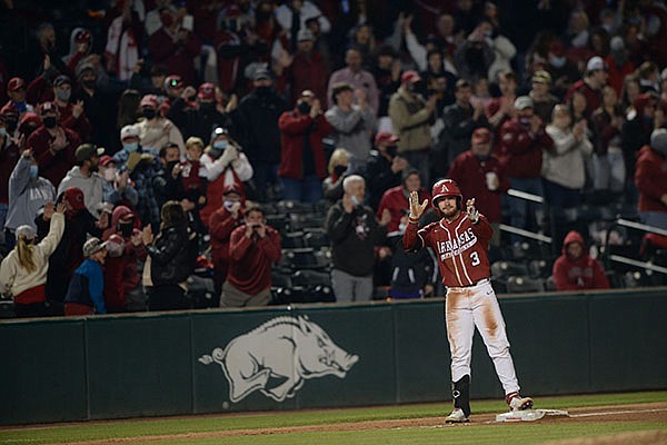 Arkansas pinch hitter Zack Gregory applauds after he hit an RBI triple during the seventh inning of a game against Auburn on Friday, April 2, 2021, in Fayetteville.