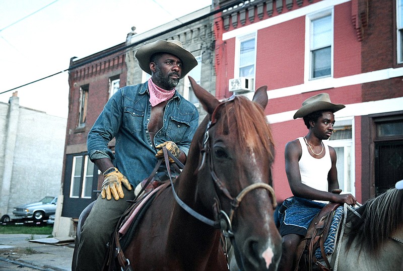 Harp (Idris Elba) tries to connect with his estranged 15-year-old son Cole (Caleb McLaughlin) in “Concrete Cowboy,” a fictional story set around the real subculture surrounding Philadelphia’s Fletcher Street Stables, one of the oldest and last-remaining of the city’s inner-city stables.