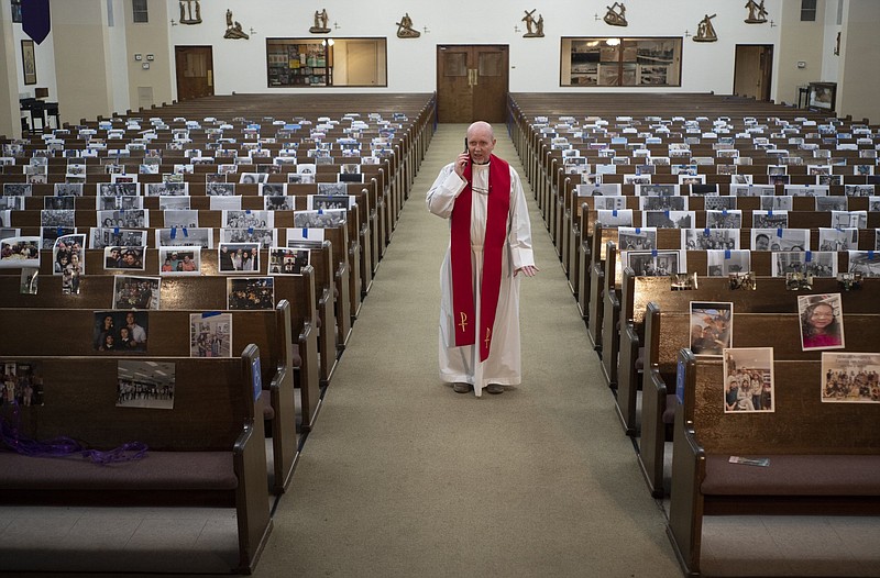 The Rev. Nicolas Sanchez takes a phone call from a parishioner after livestreaming the Good Friday Mass at St. Patrick’s Catholic Church in Los Angeles last April.
(AP/Damian Dovarganes)