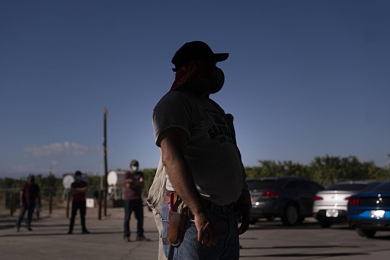 Hispanic farmworkers wait to receive covid-19 vaccinations in January in Mecca, Calif. Farmworkers are seen as vulnerable during the pandemic because they often bunk, dine and ride to fields together.
(AP file photo/Jae C. Hong)