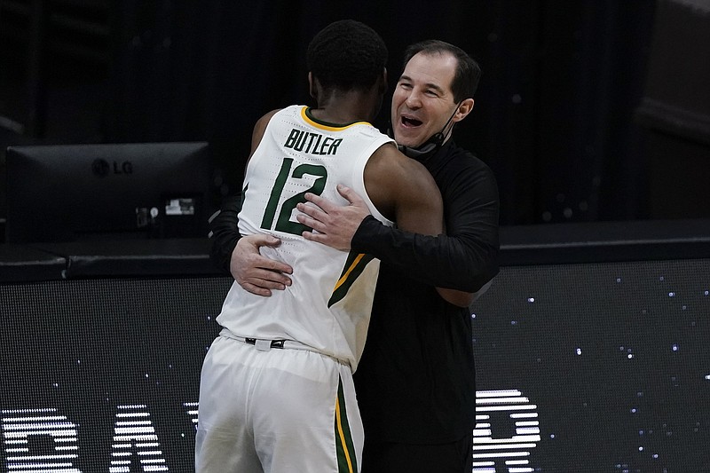 Baylor Coach Scott Drew (right) hugs Bears guard Jared Butler in the closing minutes of their victory over Houston on Saturday in the national semifinals at Indianapolis. More photos available at arkansasonline.com/44ncaa21.
(AP/Michael Conroy)