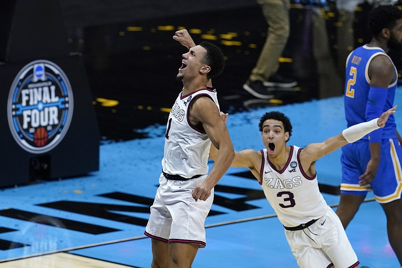 Gonzaga’s Andrew Nembhard (3) rushes to celebrate with teammate Jalen Suggs after Suggs hit agame-winning three-pointer against UCLA in the national semifinals Saturday night in Indianapolis.More photos available at arkansasonline.com/44ncaa21.
(AP/Darron Cummings)