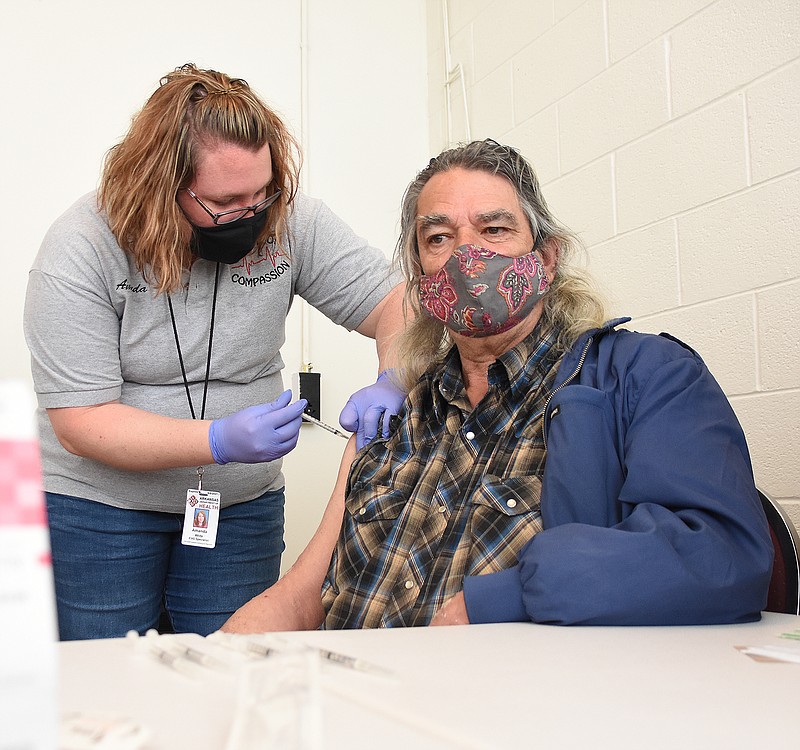 Amanda White, an EMS specialist with the Arkansas Department of Health, gives Michael Kerr a shot of the Johnson & Johnson coronavirus vaccine Thursday, April 1, 2021, at the Little Rock Compassion Center. (Arkansas Democrat-Gazette/Staci Vandagriff)