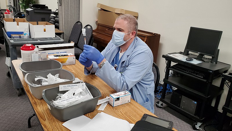 Photo by Bradly Gill
Kyle Hively, PharmD at Ouachita County Medical Center, draws from a vial containing a COVID-19 vaccine at the Green Room during Friday's vaccination clinic.