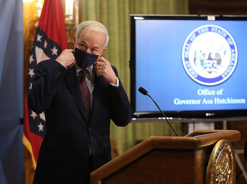 Gov. Asa Hutchinson removes his mask before the weekly covid-19 briefing on Tuesday, April 6, 2021, at the state Capitol in Little Rock. .More photos at www.arkansasonline.com/47govpress/.(Arkansas Democrat-Gazette/Thomas Metthe)