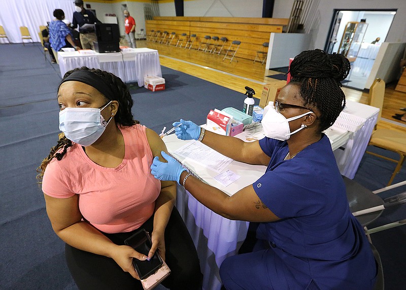 Deanna Sanders gets her covid-19 vaccine from medical assistant Makesha Tillman during the vaccine clinic on Wednesday, April 7, 2021, at Shorter College in North Little Rock. (Arkansas Democrat-Gazette/Thomas Metthe)