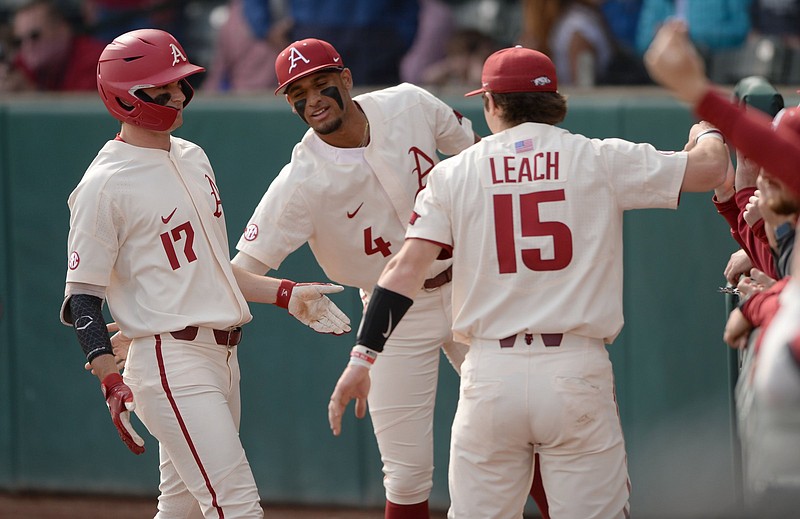 Arkansas first baseman Brady Slavens (17) is congratulated by teammates Dylan Leach (15) and Jalen Battles after hitting a three-run home run in the first inning of the Razorbacks’ victory over UALR on Wednesday at Baum-Walker Stadium in Fayetteville. Slavens was 2 for 5 with 5 RBI. More photos available at arkansasonline.com/48ualrua.
(NWA Democrat-Gazette/Andy Shupe)