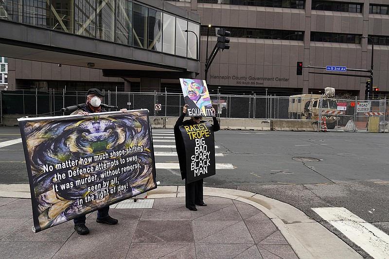 Protesters hold signs across the street from the Hennepin County courthouse Tuesday in Minneapolis where testimony continues in the trial of former Minneapolis police officer Derek Chauvin.
(AP/Jim Mone)