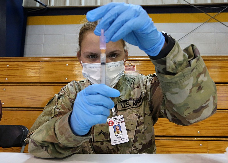 Arkansas National Guard Cpl. Katelynn Smith draws up a dose of the  Janssen covid-19 vaccine during the vaccine clinic on Wednesday, April 7, 2021, at Shorter College in North Little Rock. (Arkansas Democrat-Gazette/Thomas Metthe)