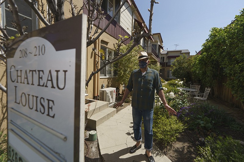 Nathan Long, a video game writer, walks outside the garden at his apartment complex in Glendale, Calif. He and his wife, Lili Chin, have been unsuccessful so far in their search for a home in Los Angeles.
(AP/Damian Dovarganes)