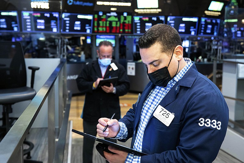 Adam Logan (foreground) works with a fellow trader Friday on the floor of the New York Stock Exchange, where technology companies helped lift stocks.
(New York Stock Exchange/AP/Colin Ziemer)