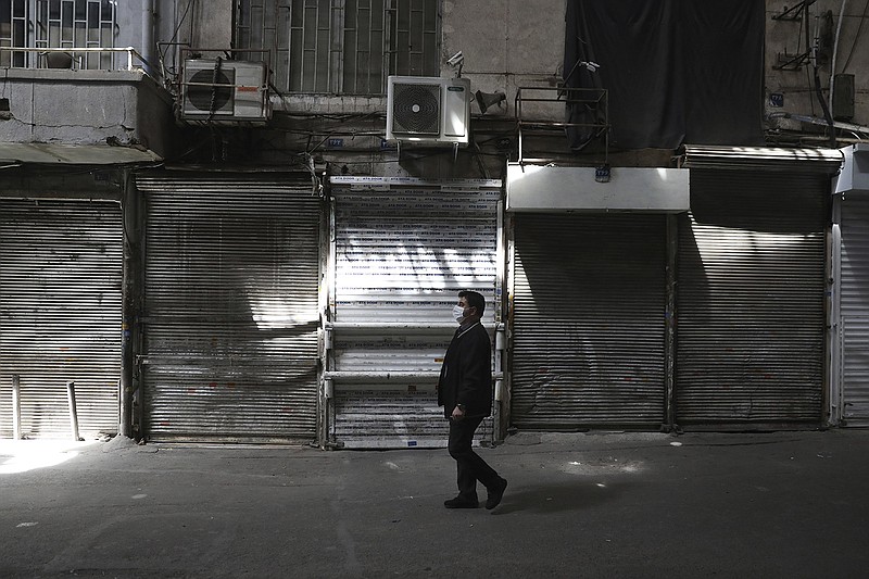 A man walks Saturday through the closed Grand Bazaar in Tehran. Iran, experiencing the worst outbreak of coronavirus in the Mideast,  has imposed a partial lockdown on businesses, shopping centers and travel in major cities.
(AP/Vahid Salemi)