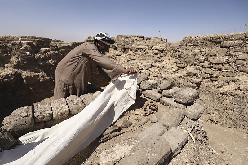 A man covers a skeleton Saturday in a 3,000-year-old lost city in Luxor province, Egypt. The newly unearthed city is between the temple of King Rameses III and the colossi of Amenhotep III on the west bank of the Nile River.
(AP/Mohamed Elshahed)