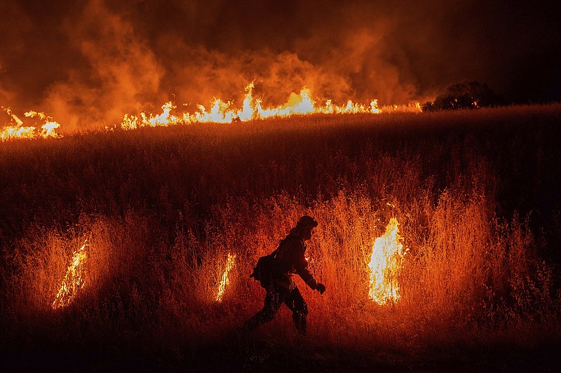 A firefighter works last June to stop the spread of flames near Winters, Calif. As fire season approaches, California is even drier this year than last year.
(AP/Noah Berger)