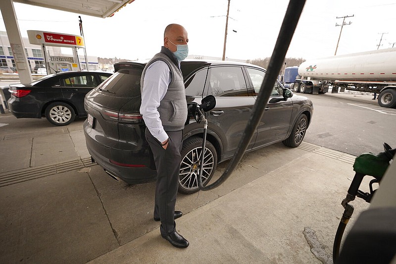 Jeremy Heskett of Boston fills his car with gasoline at a Shell gas station in Westwood, Mass., in this Feb. 18, 2021, file photo. (AP/Steven Senne)