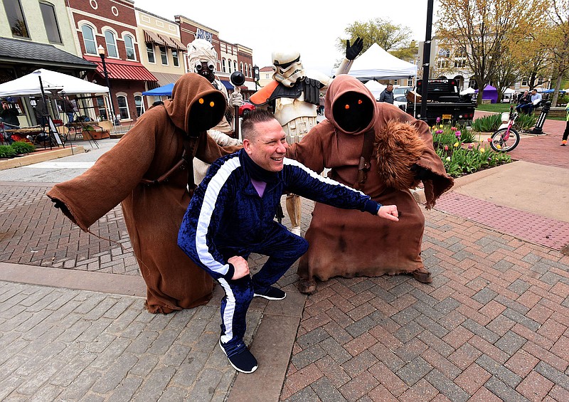 Troy Fox of Cedar Rapids, Iowa, has his picture taken Saturday with “Star Wars” characters at the Bentonville Farmers Market on the downtown square. The characters strolled through the market talking and joking with adults, children and petting the occasional dog on a leash.
(NWA Democrat-Gazette/Flip Putthoff)